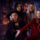 halloween_bez_napisow_3x2 Średni - Fit&More Four friends in Halloween costumes pose together at night among glowing jack-o'-lanterns; one wears a red devil outfit with a trident, others as witches and a skeleton-themed look.